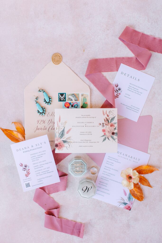Pink ribbons around invitations and other flatlay